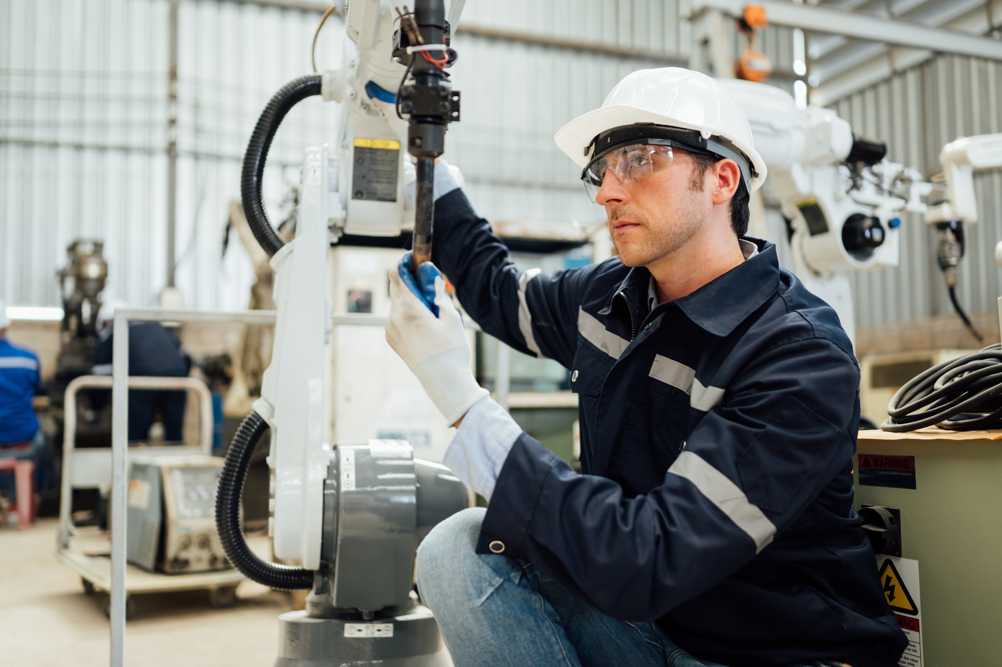 Engineer technician controlling robotic arms on computer laptop